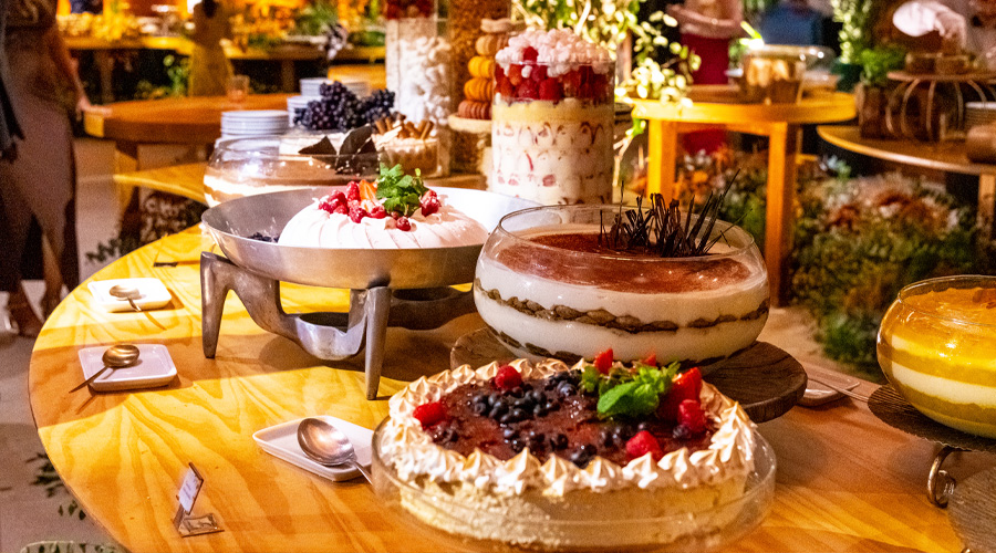 Cheesecake de frutas vermelhas, Pavlova de frutas vermelhas, tiramisù e taça de morango na ilha de sobremesas de casamento